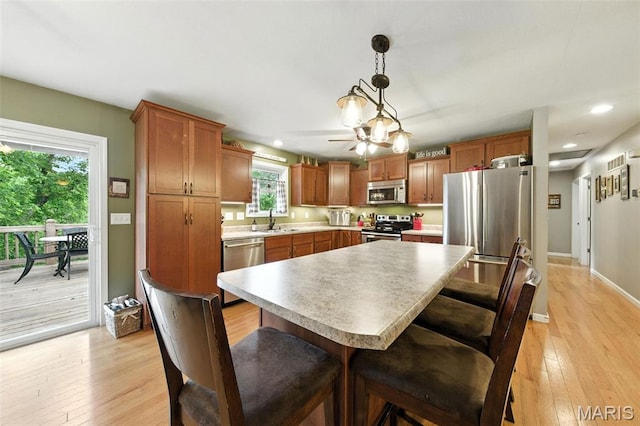 4472 Liberty Ridge Rd, De Soto, MO 63020 - kitchen featuring stainless steel appliances, recessed lighting, light wood-style flooring, light countertops, and a breakfast bar area