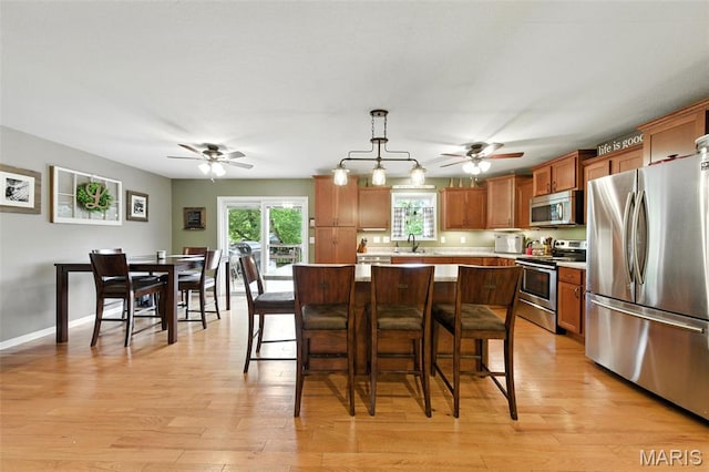 4472 Liberty Ridge Rd, De Soto, MO 63020 - kitchen with appliances with stainless steel finishes, a ceiling fan, light countertops, and brown cabinets