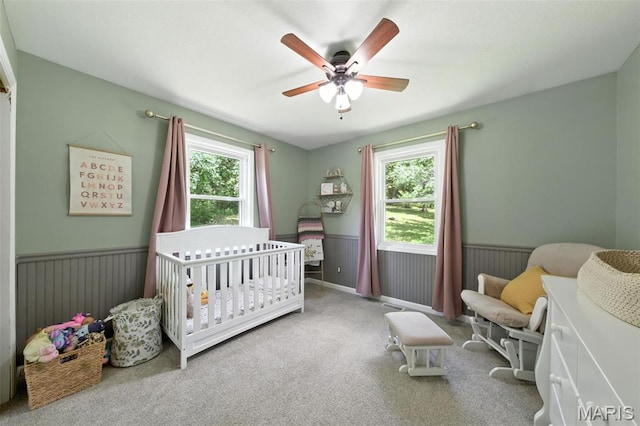 4472 Liberty Ridge Rd, De Soto, MO 63020 - bedroom featuring multiple windows, a nursery area, a wainscoted wall, carpet flooring, and ceiling fan