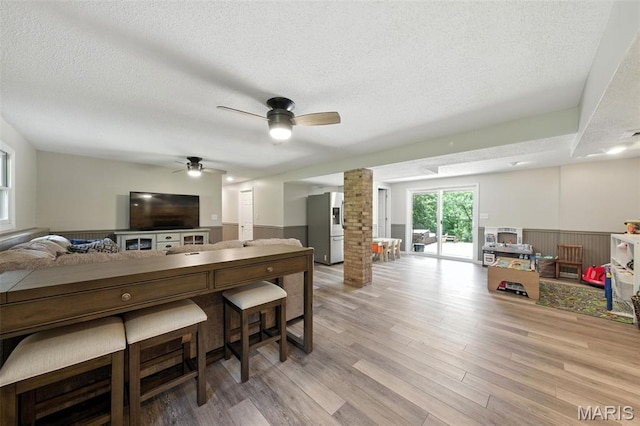 4472 Liberty Ridge Rd, De Soto, MO 63020 - kitchen featuring stainless steel refrigerator with ice dispenser, open floor plan, a textured ceiling, ornate columns, and a wainscoted wall