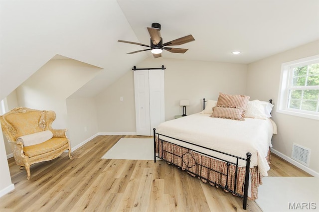300 E 11th St, Salem, MO 65560 - bedroom featuring light wood-type flooring, vaulted ceiling, a barn door, and a ceiling fan