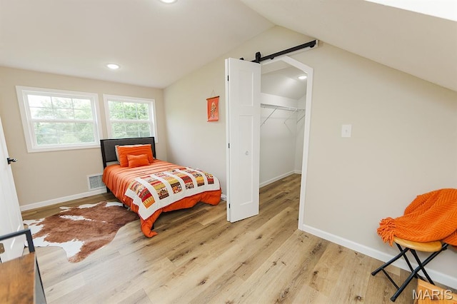 300 E 11th St, Salem, MO 65560 - bedroom with light wood finished floors, a spacious closet, vaulted ceiling, recessed lighting, and a barn door