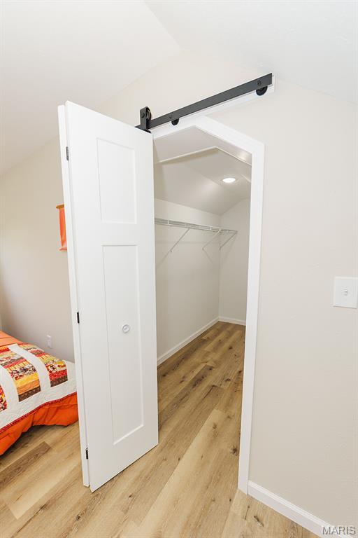 300 E 11th St, Salem, MO 65560 - spacious closet with lofted ceiling, light wood-type flooring, and a barn door
