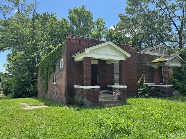 view of front of house with brick siding and a front lawn