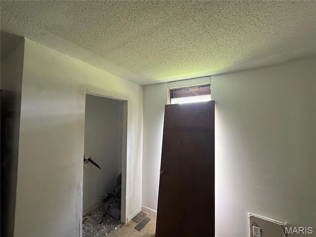 hallway with a textured ceiling