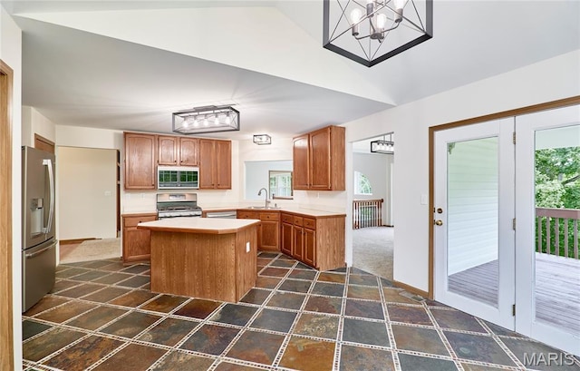 3989 Kim Kelly Dr, Harvester Township, MO 63304 - kitchen with appliances with stainless steel finishes, vaulted ceiling, a kitchen island, light countertops, and plenty of natural light