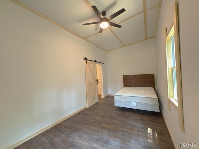 109 Preston St, Crocker, MO 65452 - unfurnished bedroom featuring dark wood-type flooring, a barn door, and a ceiling fan