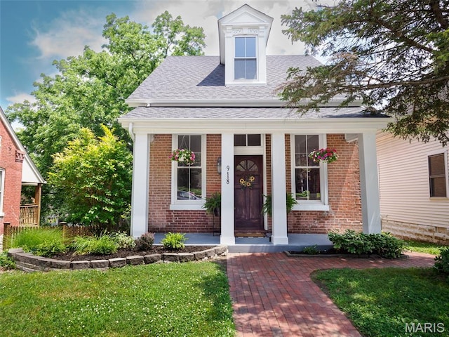 918 N 4th St, Saint Charles, MO 63301 - view of front of house featuring a porch, brick siding, and a shingled roof