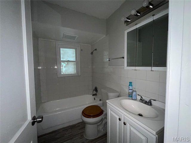 605 Abston Ave, Saint Louis, MO 63135 - bathroom featuring vanity, tile walls,  shower combination, and decorative backsplash