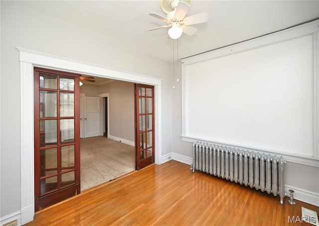 5322 Lansdowne Ave, Saint Louis, MO 63109 - spare room with radiator heating unit, a ceiling fan, wood finished floors, and french doors