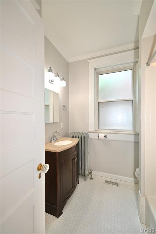 5322 Lansdowne Ave, Saint Louis, MO 63109 - full bath featuring vanity, crown molding, radiator heating unit, a bath, and a shower