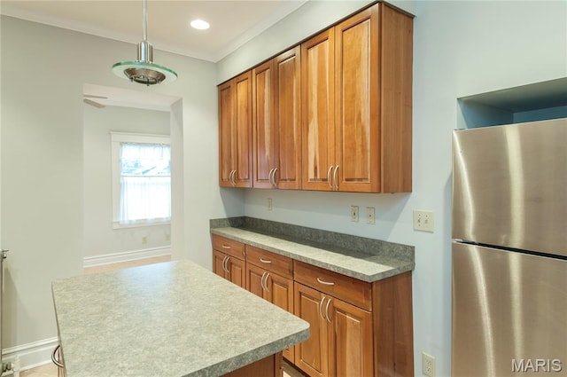 5322 Lansdowne Ave, Saint Louis, MO 63109 - kitchen with freestanding refrigerator, brown cabinetry, a center island, hanging light fixtures, and ornamental molding