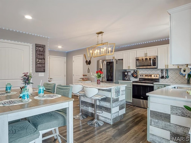 1050 Creekside Dr, Waterloo, IL 62298 - kitchen featuring appliances with stainless steel finishes, light countertops, dark wood-style floors, tasteful backsplash, and white cabinetry