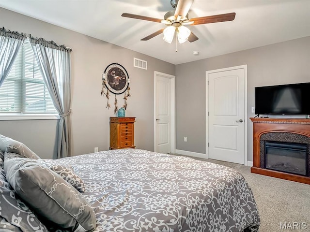 1050 Creekside Dr, Waterloo, IL 62298 - carpeted bedroom with ceiling fan and a glass covered fireplace