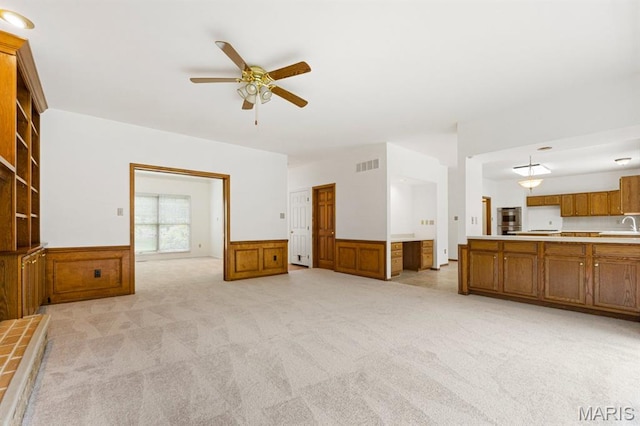 265 Timber Tree Ct, Wildwood, MO 63011 - unfurnished living room featuring ceiling fan, a wainscoted wall, and light carpet