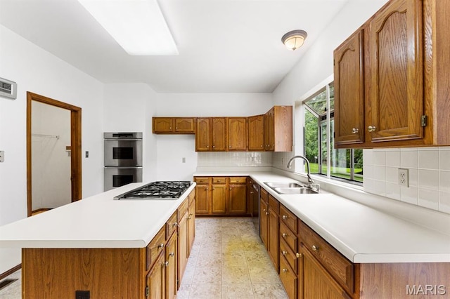 265 Timber Tree Ct, Wildwood, MO 63011 - kitchen with appliances with stainless steel finishes, brown cabinets, light countertops, decorative backsplash, and a kitchen island