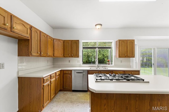 265 Timber Tree Ct, Wildwood, MO 63011 - kitchen featuring appliances with stainless steel finishes, brown cabinetry, backsplash, and light countertops