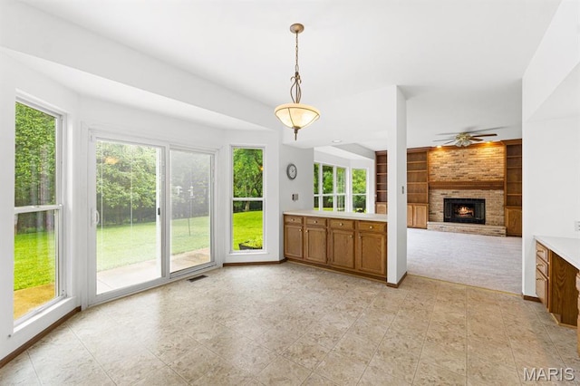 265 Timber Tree Ct, Wildwood, MO 63011 - unfurnished living room featuring a brick fireplace, built in shelves, ceiling fan, light tile patterned floors, and light carpet