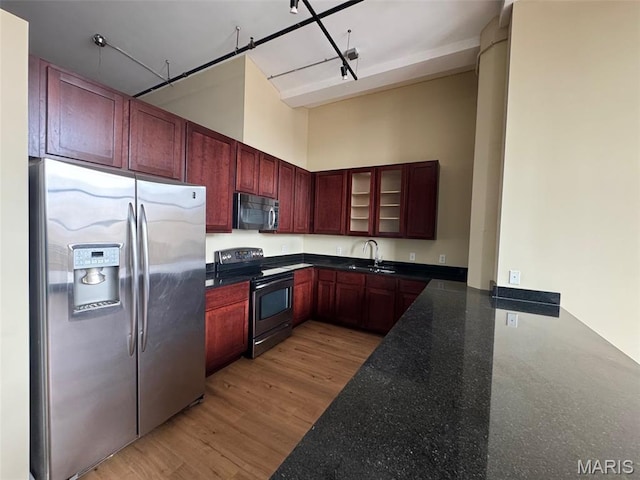 1520 Washington Ave Unit 617, Saint Louis, MO 63103 - kitchen with stainless steel appliances, dark stone counters, dark brown cabinets, glass insert cabinets, and a high ceiling