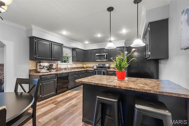 1004 Willow Ln, Sikeston, MO 63801 - kitchen featuring stainless steel appliances, a kitchen breakfast bar, light wood finished floors, ornamental molding, and a peninsula