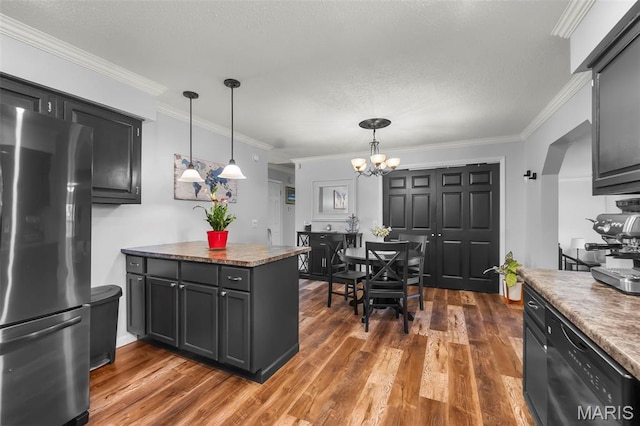 1004 Willow Ln, Sikeston, MO 63801 - kitchen with freestanding refrigerator, dark wood finished floors, a chandelier, crown molding, and decorative light fixtures