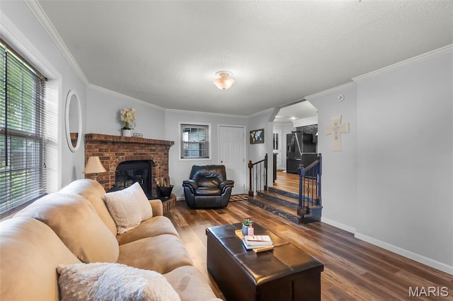 1004 Willow Ln, Sikeston, MO 63801 - living room with wood finished floors, a brick fireplace, ornamental molding, a textured ceiling, and stairs