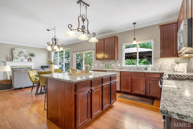 714 Oriental Lily Dr, Ofallon, MO 63366 - kitchen with appliances with stainless steel finishes, tasteful backsplash, light wood-style floors, light stone counters, and ornamental molding