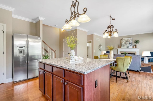 714 Oriental Lily Dr, Ofallon, MO 63366 - kitchen with stainless steel refrigerator with ice dispenser, light wood-style floors, a kitchen island, hanging light fixtures, and crown molding
