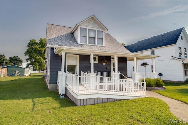 408 N N Main St, Carrollton, IL 62016 - view of front of home with covered porch, a shingled roof, and a front yard