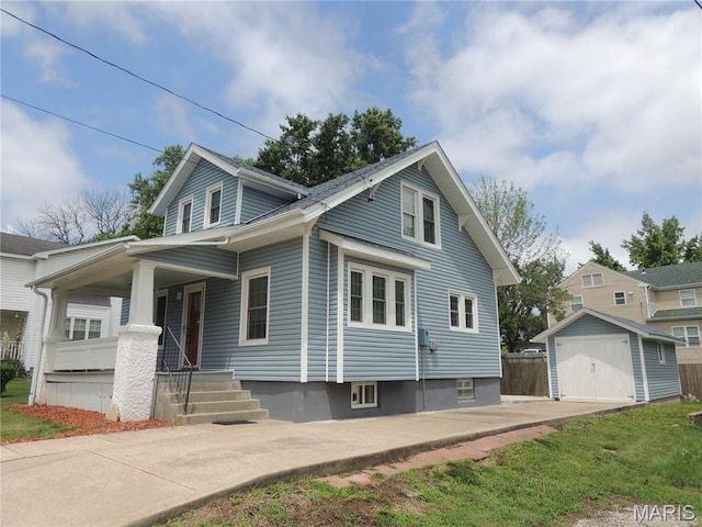 1203 E Jackson St, Mexico, MO 65265 - view of front of house featuring a porch, a detached garage, and a storage unit