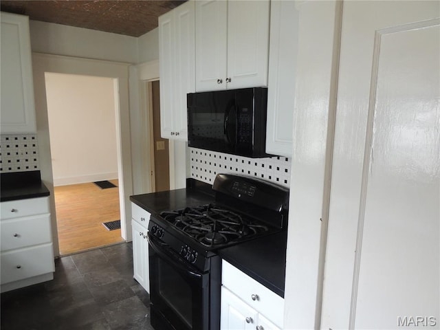 1203 E Jackson St, Mexico, MO 65265 - kitchen with black appliances, dark countertops, and white cabinetry