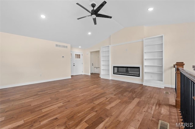225 Ranchero Dr, Hamel, IL 62046 - unfurnished living room featuring a glass covered fireplace, a ceiling fan, wood finished floors, lofted ceiling, and built in features
