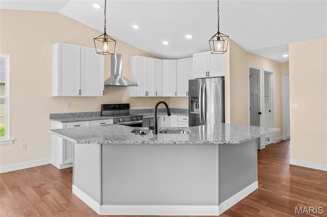 225 Ranchero Dr, Hamel, IL 62046 - kitchen featuring appliances with stainless steel finishes, wall chimney exhaust hood, vaulted ceiling, light wood-style flooring, and white cabinets