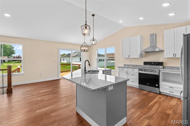 225 Ranchero Dr, Hamel, IL 62046 - kitchen with wall chimney range hood, stainless steel appliances, vaulted ceiling, a center island with sink, and white cabinets