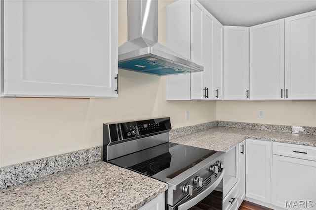 225 Ranchero Dr, Hamel, IL 62046 - kitchen with wall chimney range hood, electric range, white cabinetry, and light stone counters