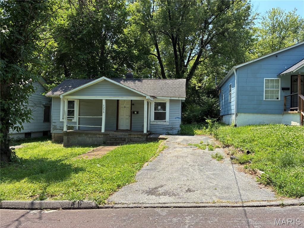 7206 Albright Ave, Jennings, MO 63136 - bungalow-style home featuring a porch and driveway
