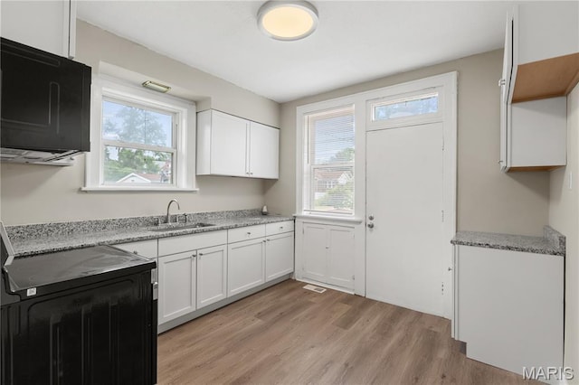 3800 Oakridge Blvd, Northwoods, MO 63121 - kitchen featuring light wood-style floors, white cabinets, light stone countertops, and range