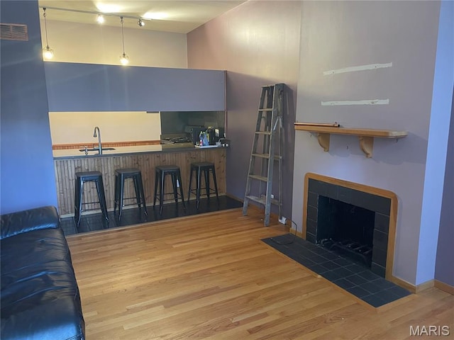 2319 Hickory St Unit A, Saint Louis, MO 63104 - living room featuring wood finished floors, a tile fireplace, and bar area