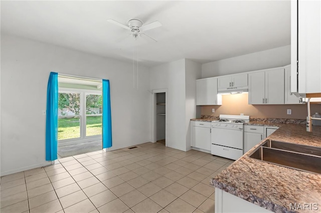 224 E Velma Ave, Lemay Township, MO 63125 - kitchen featuring white range with gas stovetop, under cabinet range hood, ceiling fan, white cabinets, and light tile patterned floors