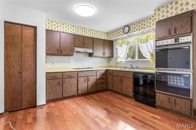 2844 Deborah Ann Dr, Arnold, MO 63010 - kitchen featuring multiple ovens, dishwasher, under cabinet range hood, light countertops, and light wood-style flooring