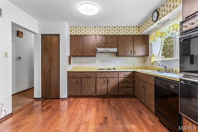 2844 Deborah Ann Dr, Arnold, MO 63010 - kitchen with black appliances, under cabinet range hood, light countertops, and dark wood-type flooring