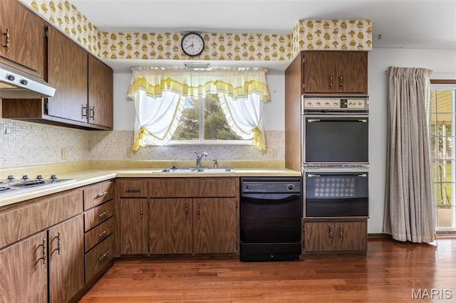 2844 Deborah Ann Dr, Arnold, MO 63010 - kitchen with dishwasher, multiple ovens, dark wood-style floors, cooktop, and light countertops