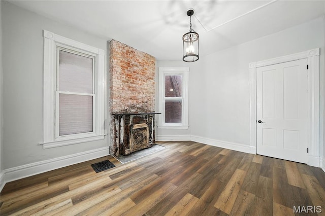 4550 Enright Ave, Saint Louis, MO 63108 - unfurnished living room featuring wood finished floors and a chandelier