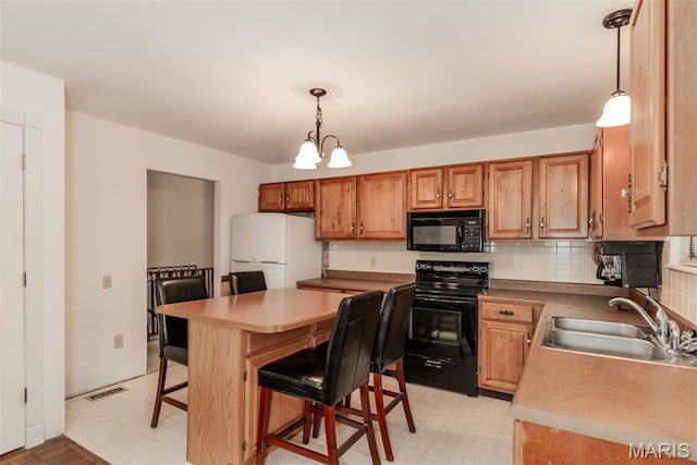 18 Novella Dr, Saint Peters, MO 63376 - kitchen featuring black appliances, a breakfast bar area, pendant lighting, and backsplash