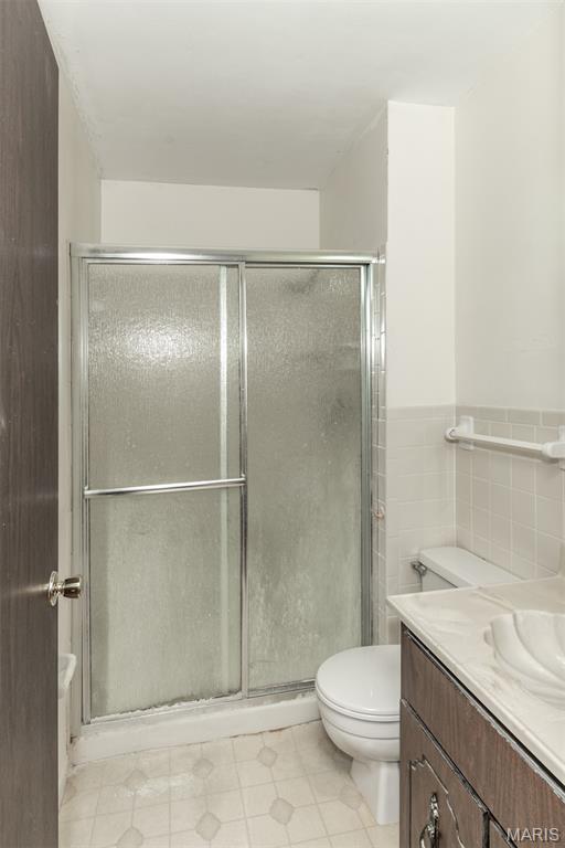 18 Novella Dr, Saint Peters, MO 63376 - bathroom featuring vanity, a shower with door, tile patterned floors, and tile walls