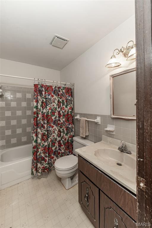 18 Novella Dr, Saint Peters, MO 63376 - full bathroom featuring vanity, shower / bathtub combination with curtain, tile walls, tile patterned floors, and a wainscoted wall