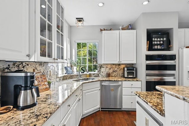 923 Legends View Dr, Eureka, MO 63025 - kitchen with stainless steel appliances, light stone countertops, white cabinets, glass insert cabinets, and recessed lighting