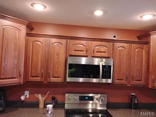 1107 Daffodil St, Sikeston, MO 63801 - kitchen with appliances with stainless steel finishes, dark countertops, brown cabinets, and recessed lighting