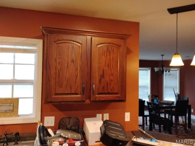 1107 Daffodil St, Sikeston, MO 63801 - kitchen with a chandelier, healthy amount of natural light, brown cabinetry, and decorative light fixtures