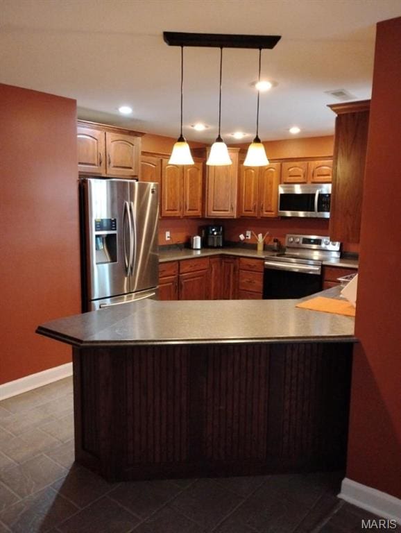 1107 Daffodil St, Sikeston, MO 63801 - kitchen with stainless steel appliances, a peninsula, dark tile patterned floors, hanging light fixtures, and recessed lighting